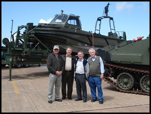 John Hamnett, George Smart/, Mick Allen and Carlton Brown pose in front of Military vehicles at HMS Chivenor.