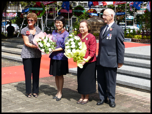 Jeanne Edwards and Jim Curtis present a bouquet of flowers to Mother Ubon's relative and the Governor's wife.