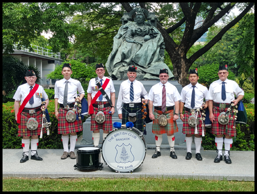 The Bangkok Pipe Band pose for a group picture.
