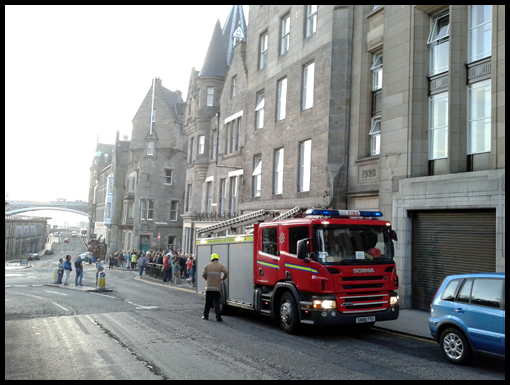 A Fire Engine parks outside the hotel whilst the guests stand on the pavement.