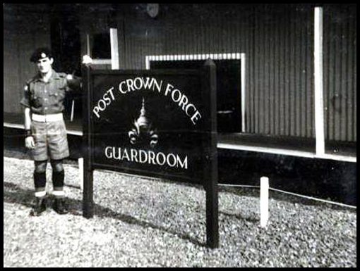 Jim Parking in his role of RP standing beside the Crown Guardroom sign.
