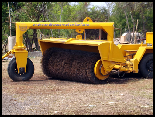 A picture of a yellow runway brushing machine.