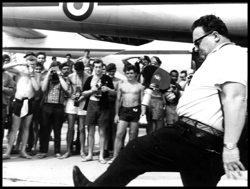 Harry Secombe shows a leg on arrival at Crown Airfield.