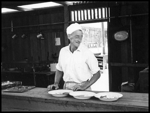 Harry Colly serves up the food he's just cooked.