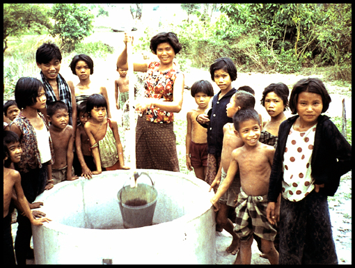 Happy Thai village children draw water from a well rather than walking long distances to collect it.