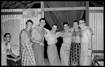 A group of cooks pose in a male version of a sarong made from locally made cloth