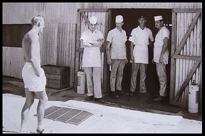 A group of cooks stand at the open kitchen door 