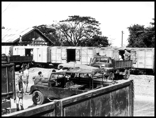 Marquee tents are loaded on to Bedford RL's from railway carriages in the Ubon freight yards by men of 3 Coy RASC.