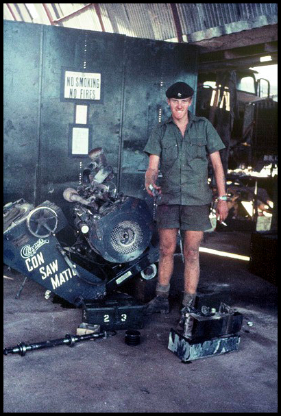 John Lloyd stands beside the Con Saw Matic machine he's repairing